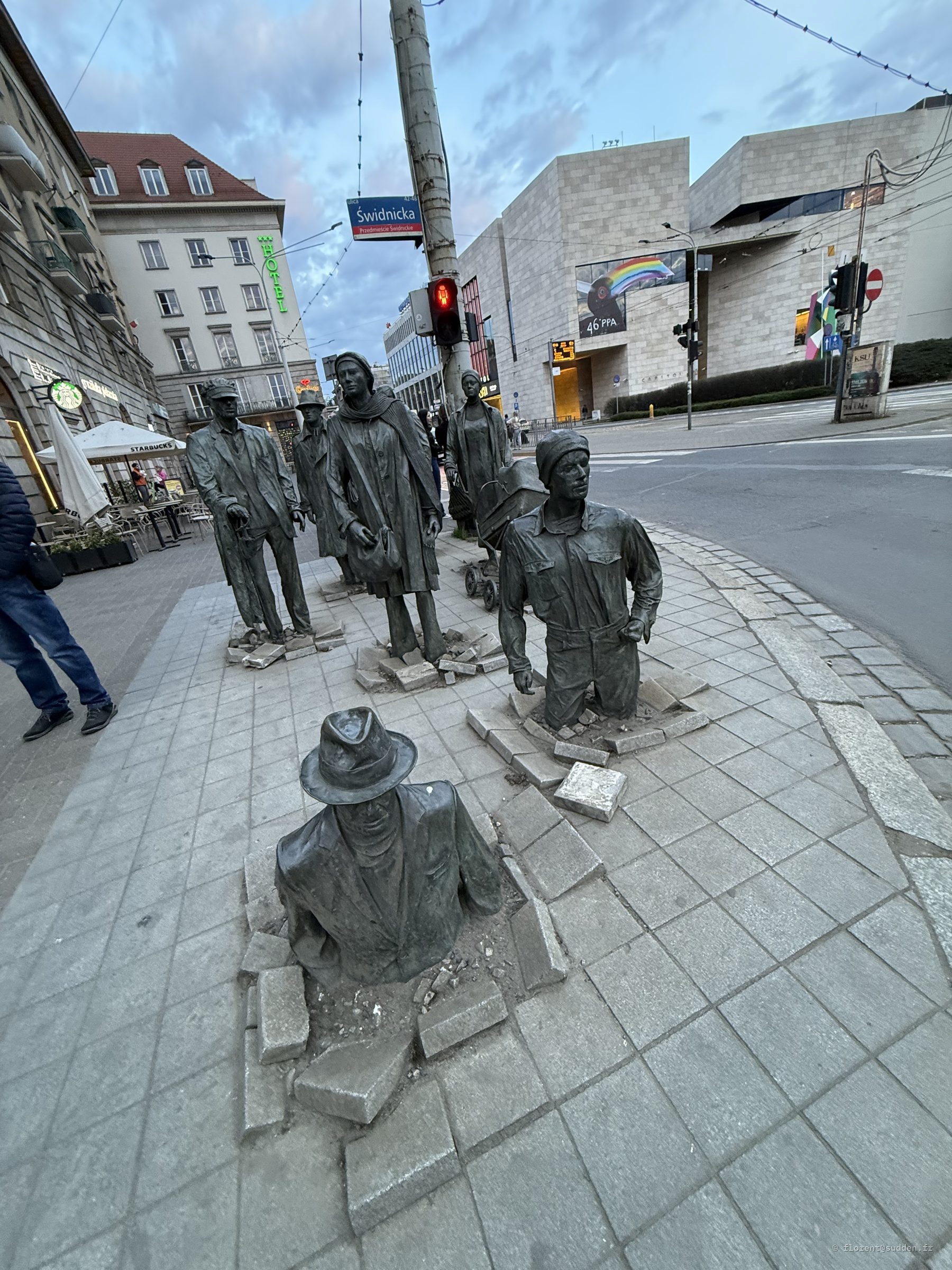 Statues de bronze grandeur nature disparaissant dans le trottoir, monument de la Traversée à Wrocław
