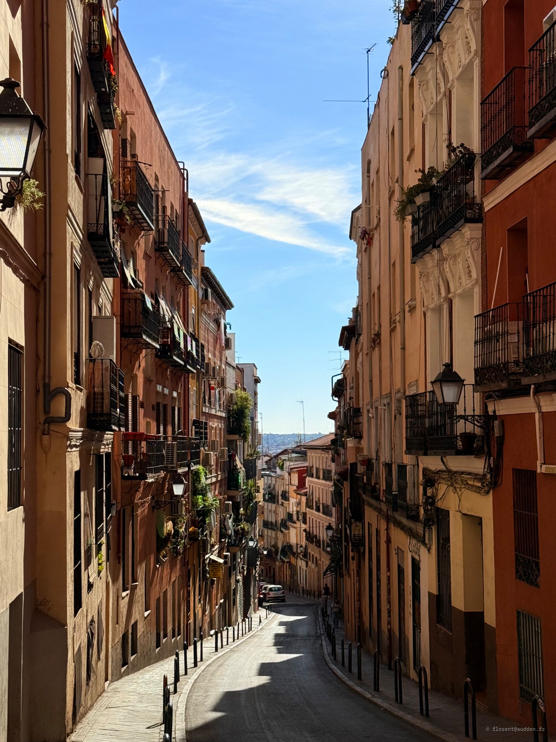 Rue en pente : La rue plonge, la lumière suit.